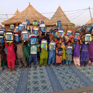 group of kids holding up new backpacks